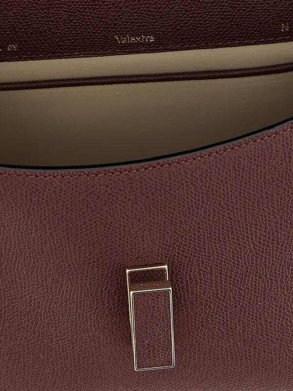 Close-up of a brown leather bag with a visible brand logo.