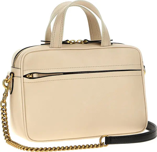 Beige handbag with gold chain and black strap on a white background