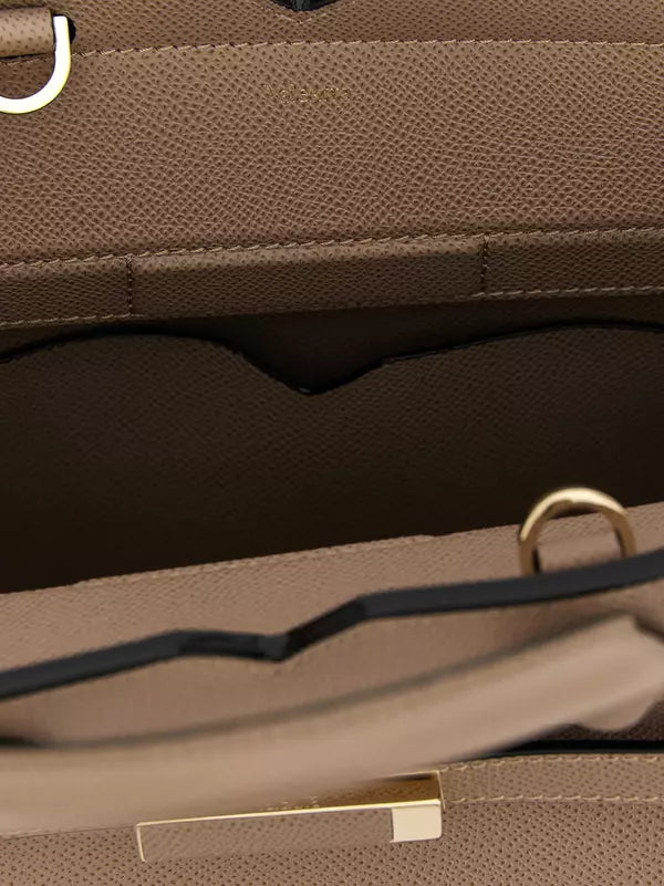 Close-up of a brown leather handbag with a gold clasp.