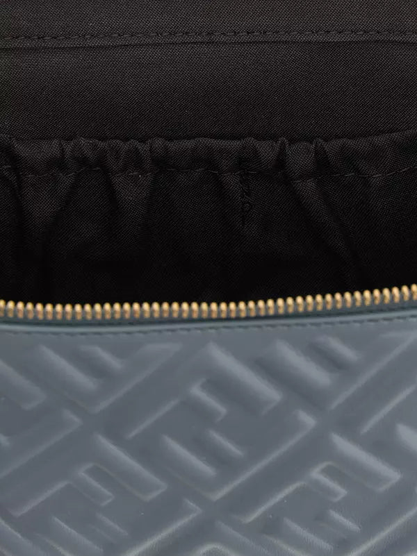 Close-up of a black fabric surface with a gold zipper and blue textured fabric below.