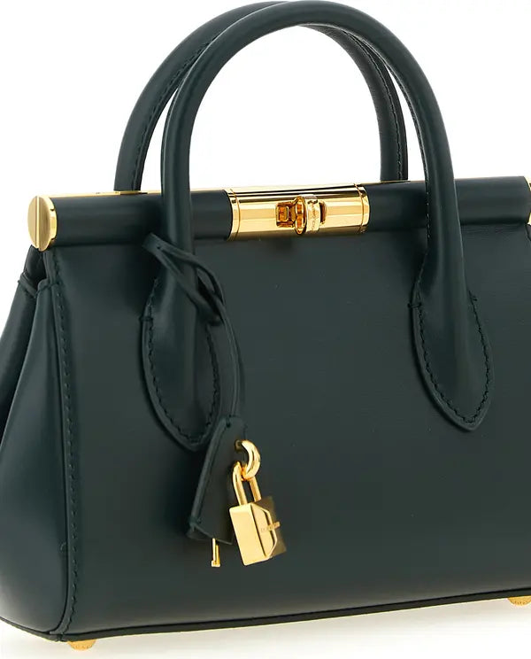 Black handbag with gold accents on a white background