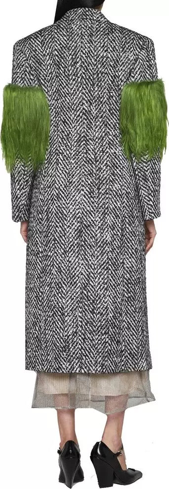 Long coat with herringbone pattern and green sleeves worn by a person.