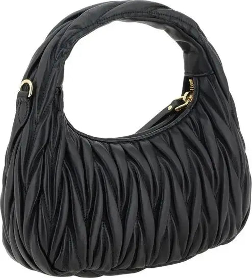Black quilted leather shoulder bag with a curved top handle and gold-tone hardware, shown on a plain white background.