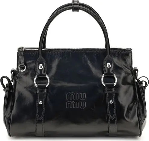 A black patent leather Miu Miu handbag with silver-tone hardware, featuring dual top handles, a top zipper, and the embossed Miu Miu logo on the front.