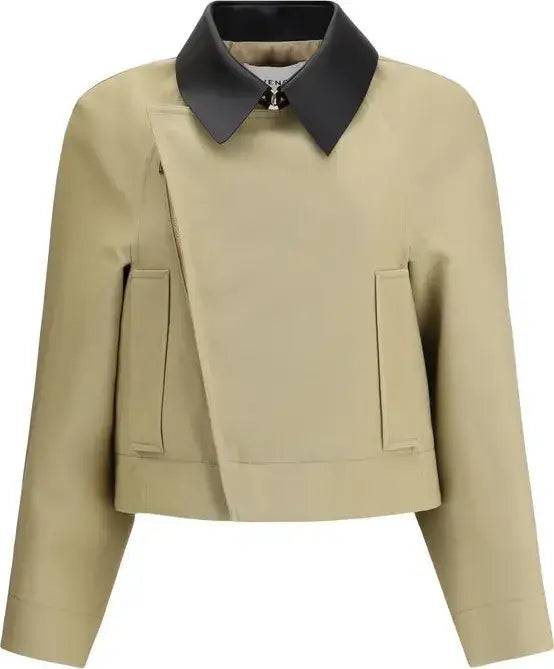 A cropped beige jacket with an asymmetrical wrap-style front, long sleeves, and two vertical front pockets, featuring a contrasting dark charcoal collar with a small decorative clasp at the neck.