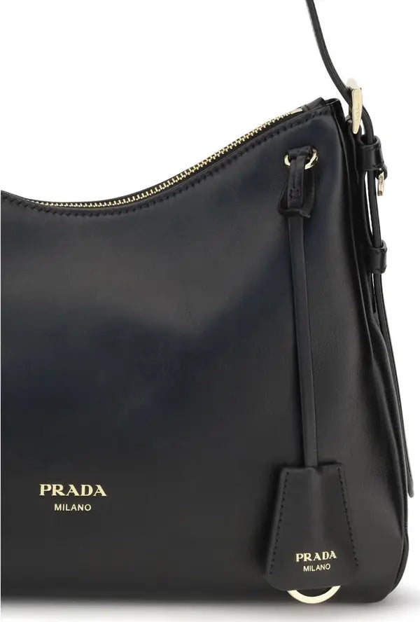 Black Prada Milano leather shoulder bag with gold-tone hardware and logo, featuring a hanging leather tag and a top zipper closure.