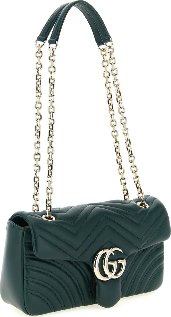 A dark green quilted leather shoulder bag with a silver-tone chain strap and a prominent interlocking GG logo on the front, set against a plain white background.
