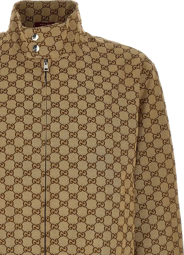 Close-up of a brown and beige monogram patterned jacket with a stand collar and front zipper, showing the repeating interlocking GG pattern.