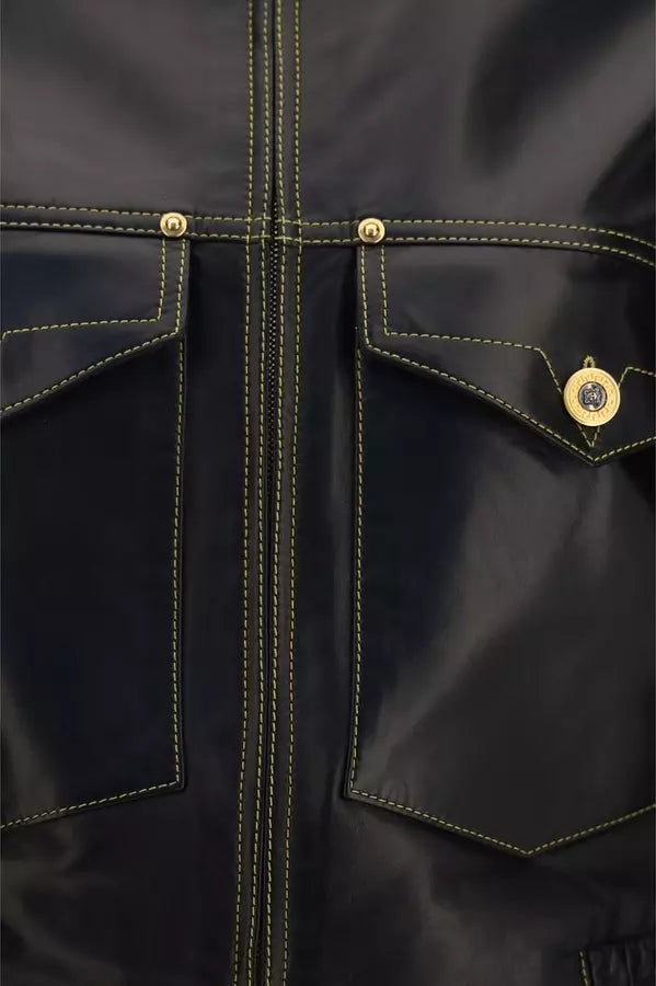 Close-up of a dark navy jacket with yellow contrast stitching, featuring two front flap pockets and gold-tone metal snap buttons.