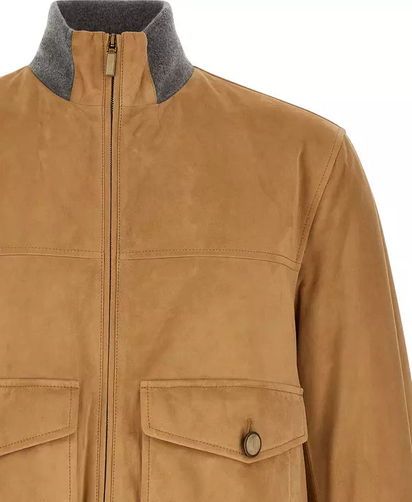 A close-up of a tan suede jacket featuring a gray fleece collar and a front zipper, with a buttoned flap pocket visible on the lower front.