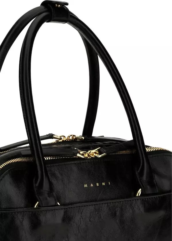 Close-up of a black leather handbag with double top handles, gold-tone hardware, and the brand name &
