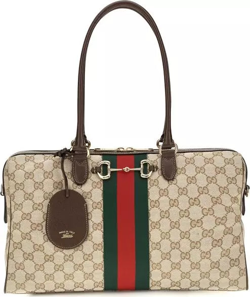 Gucci Horsebit Satchel in beige GG Supreme canvas with brown leather handles, a brown leather hangtag, and the signature green and red web stripe down the center.