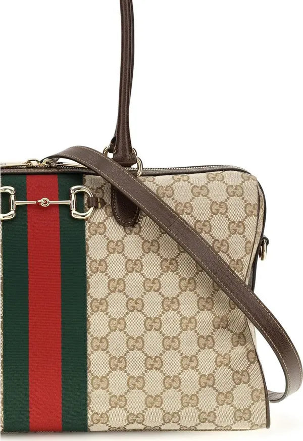 Gucci GG Supreme canvas tote bag with brown leather trim, a green and red web stripe, and gold-tone horsebit hardware on a white background.