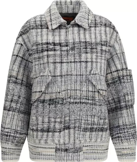 A textured, long-sleeve plaid jacket in a black and white heathered fabric, featuring a collar, button-up front, and large front pockets.