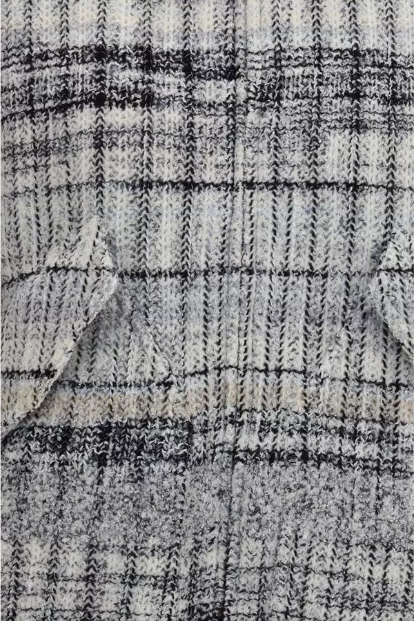 Close-up of a textured knit fabric with a black and off-white plaid pattern.