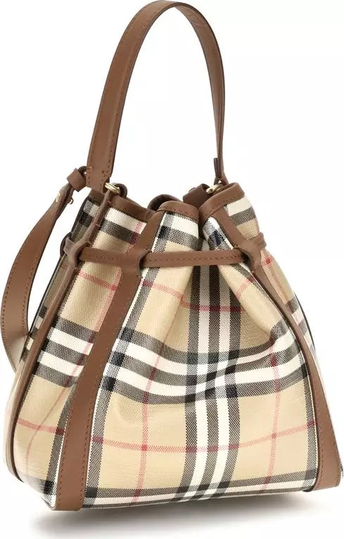 A classic plaid bucket bag in beige, brown, black, and white with a tan leather handle and trim, shown on a white background.