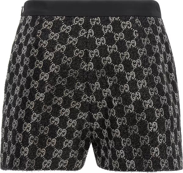 Black Gucci shorts featuring an all-over sparkling interlocking GG monogram pattern, with a solid black elastic waistband.