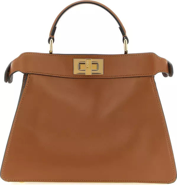 A structured tan leather handbag with a top handle, a flap closure, and a prominent gold-tone turn-lock clasp on the front, shown against a plain white background.