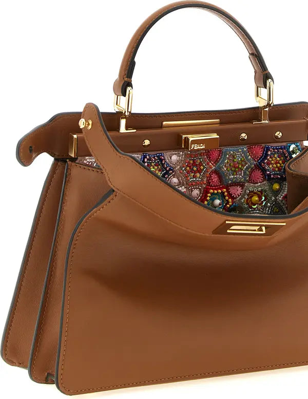 A Fendi brown leather handbag with gold-tone hardware and a colorful embroidered fabric panel visible inside the open top handle, shown on a white background.