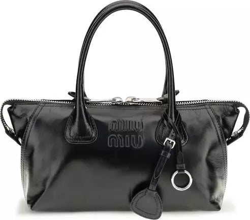 A black Miu Miu leather handbag with dual top handles, a top zipper closure, and a silver-tone ring charm, shown against a plain white background.