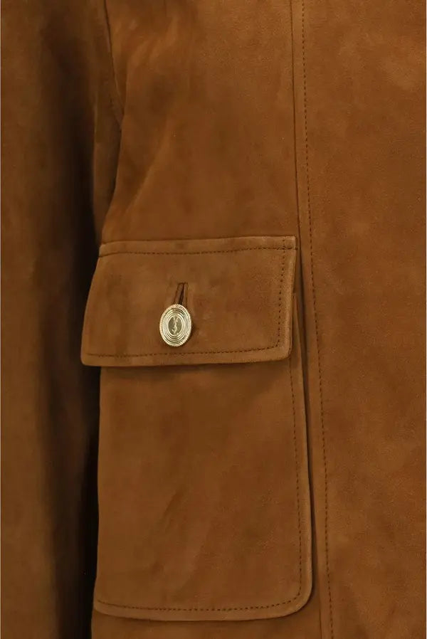 Close-up of a brown suede jacket featuring a flap pocket with a silver-tone metal snap button.