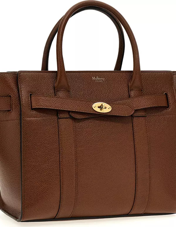 A brown textured leather Mulberry handbag with double top handles, a front strap detail, and a gold-tone turn-lock closure on a white background.