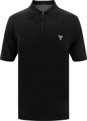 A black short-sleeve polo shirt with a half-zip collar and a small white embroidered logo on the left chest, shown against a plain white background.