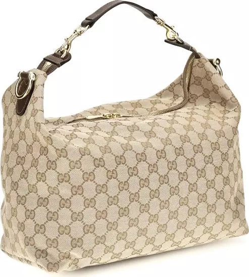 A Gucci hobo shoulder bag in beige GG Supreme canvas with brown leather trim and gold-tone hardware, shown on a plain white background.