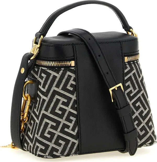 Black leather and patterned handbag with gold-tone hardware, featuring a top handle, zippered compartments, and a detachable shoulder strap on a white background.