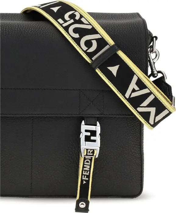 Black pebbled leather crossbody bag with a wide black strap featuring white Fendi logo lettering and gold trim, plus a matching black and gold front strap detail.