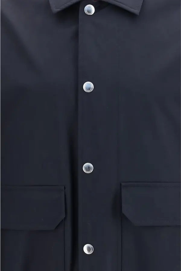 Close-up of a dark navy or black button-up shirt with silver-toned buttons and flap chest pockets.