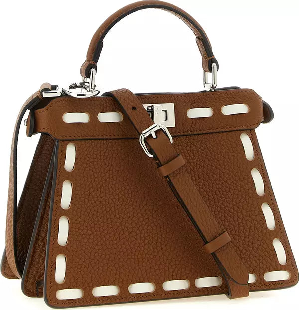 A structured brown pebbled leather handbag with a top handle, shoulder strap, and silver-tone hardware, featuring decorative cutout detailing along the front.