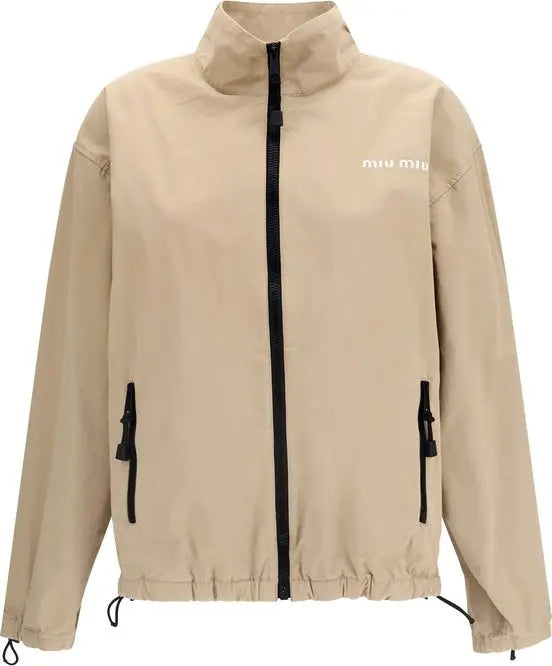 A beige Miu Miu lightweight jacket with a black front zipper, black zippered hand pockets, and white &