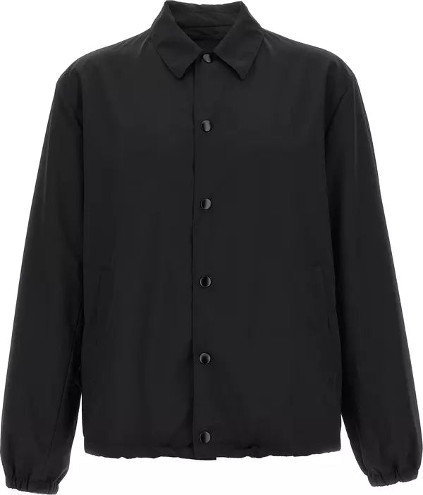 A black long-sleeve jacket with a pointed collar, button-up front, and elasticized cuffs, shown on a plain white background.
