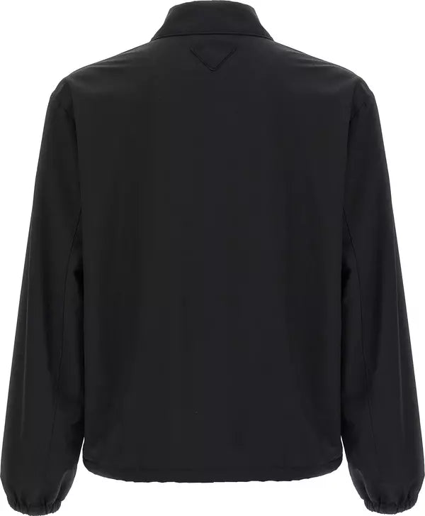 Black long-sleeve jacket shown from the back, featuring a stand-up collar and elasticized cuffs, photographed against a plain white background.