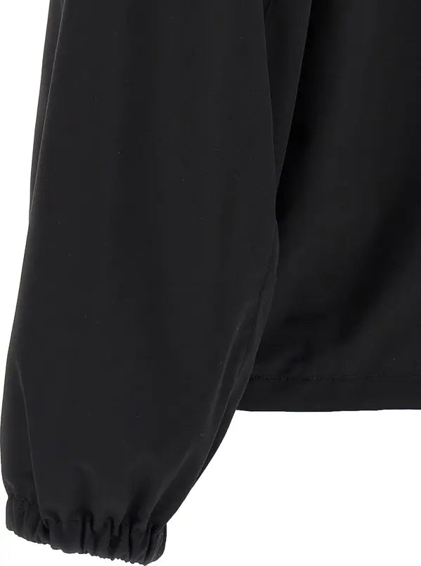 Close-up of a black long-sleeve garment with an elasticized cuff, showing the fabric texture and sleeve construction against a white background.