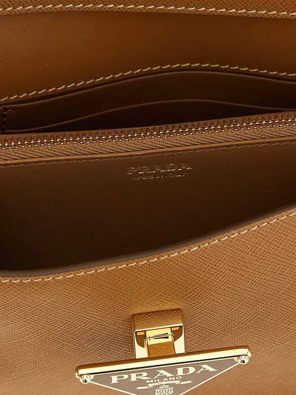 Close-up of the interior of a Prada handbag in tan leather, showing the zippered compartment, interior branding, and a gold-tone triangular Prada logo clasp.