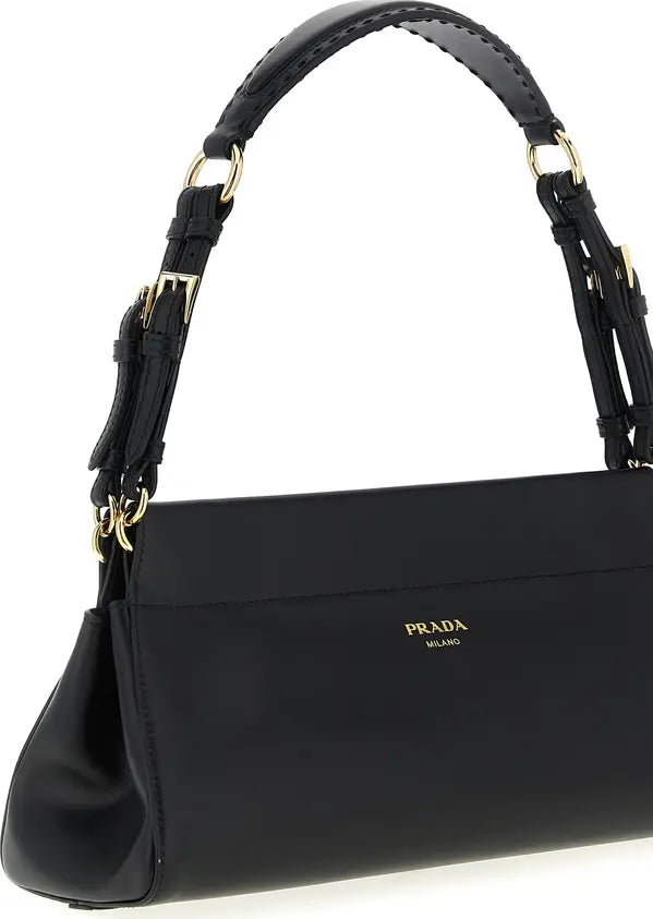 A black Prada shoulder bag with gold-tone hardware and a small gold logo on the front, shown against a plain white background.