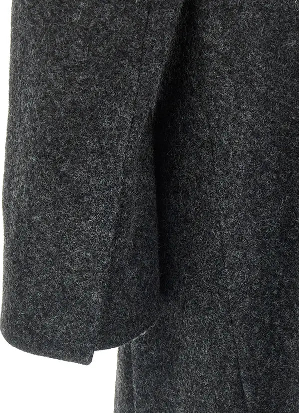 Close-up of a dark charcoal gray textured fabric, showing the fine woven pattern and a folded cuff detail against a white background.