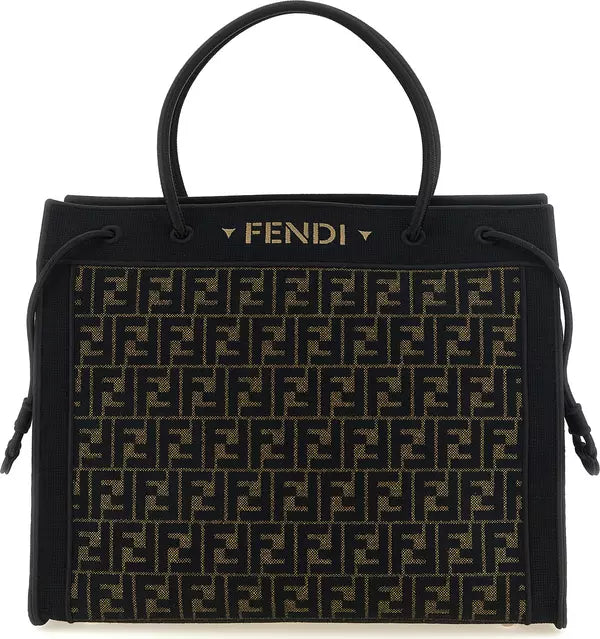 Fendi black monogram canvas tote bag with gold Fendi logo on the front, black leather handles, and black drawstring details on a white background.