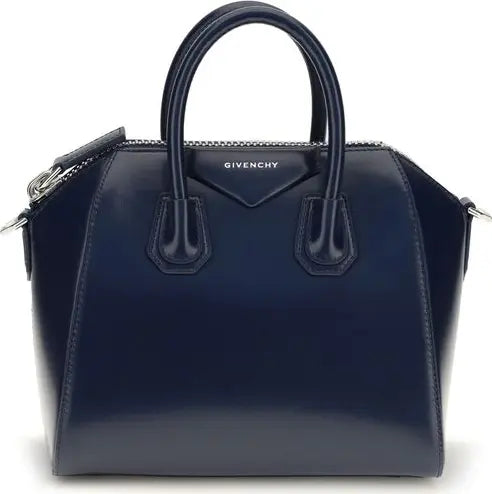 A navy blue Givenchy Antigona handbag with a glossy patent finish, featuring dual top handles, silver-tone hardware, and the brand name &