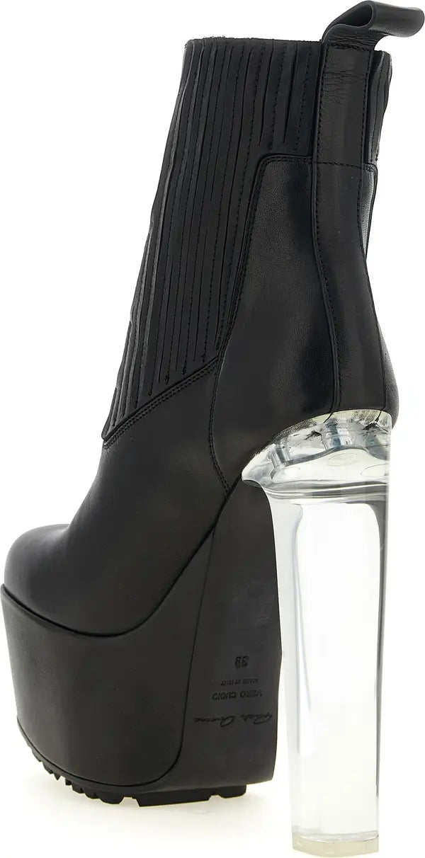 A black leather ankle boot with a ribbed knit side panel and a very high platform sole, featuring a clear acrylic block heel on a white background.