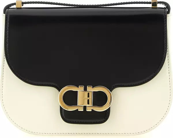 A Salvatore Ferragamo shoulder bag in black and off-white leather with a gold-tone Gancini clasp and a thin black leather strap.