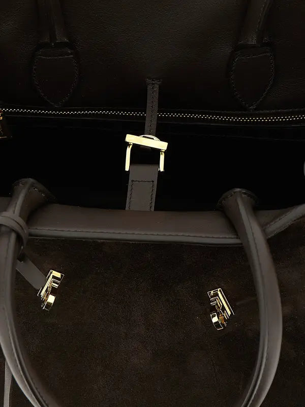 Close-up of a black leather bag with gold hardware