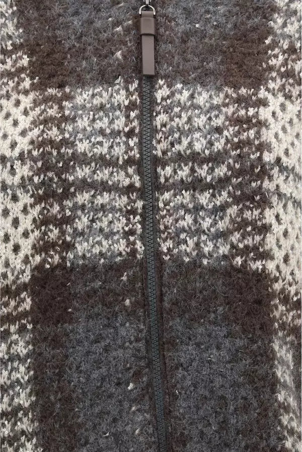 Close-up of a zippered knit garment with a textured plaid pattern in dark brown, charcoal gray, and off-white. A dark brown fabric pull tab is visible at the top center.