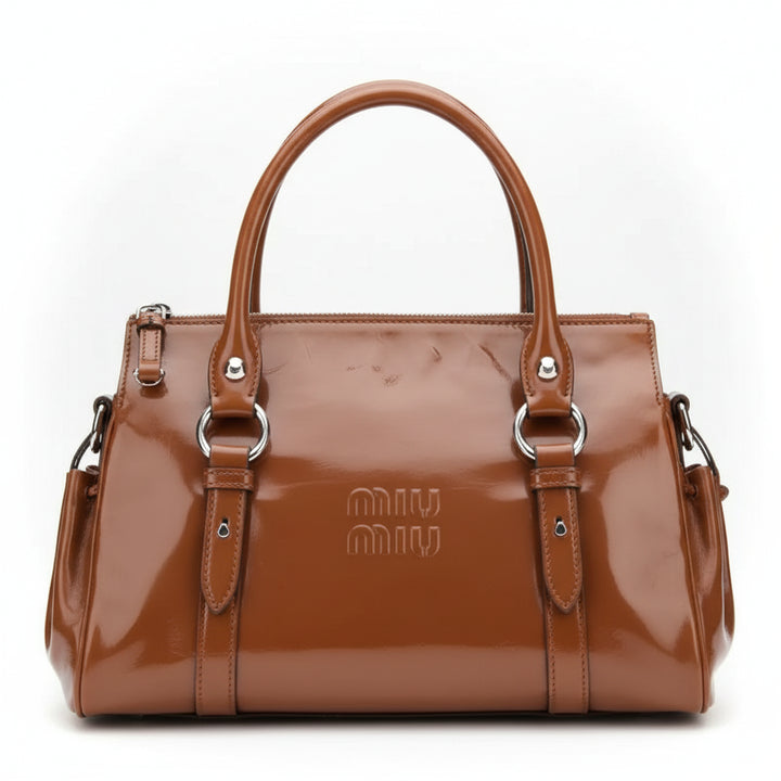 A brown patent leather Miu Miu handbag with top handles, side pockets, and silver-tone hardware, shown against a plain white background.