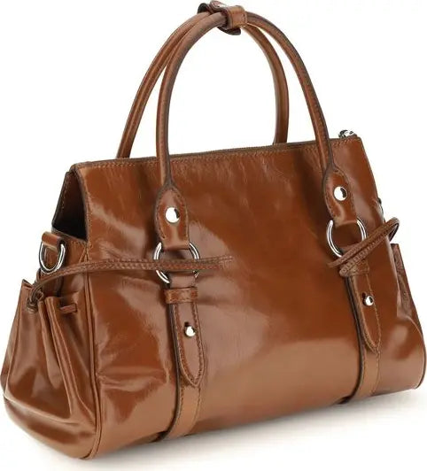 A brown glossy leather handbag with double top handles, side pockets, and silver-tone metal hardware, shown on a plain white background.