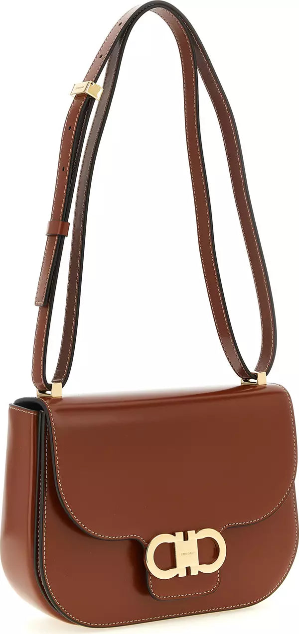 A brown leather shoulder bag with a gold-tone &
