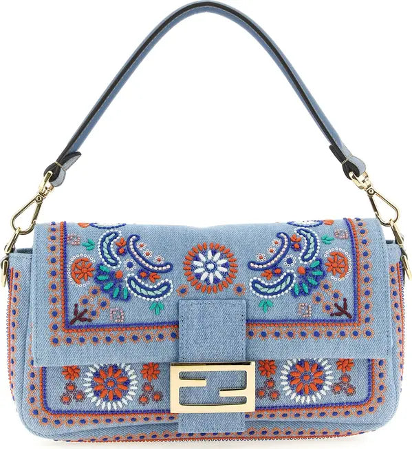 A light blue denim shoulder bag with intricate multicolor embroidered patterns, a gold-tone Fendi FF logo clasp, and a dark blue leather strap with gold hardware, shown on a white background.