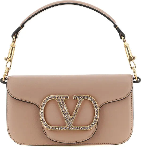 A beige leather handbag with a large gold-tone &